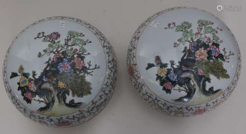 Pair of porcelain covered boxes. China. Early 20th century. Famille Rose decoration of peacocks, flowering trees and poems. Borders of stylized lotus scrolls. 10-1/2