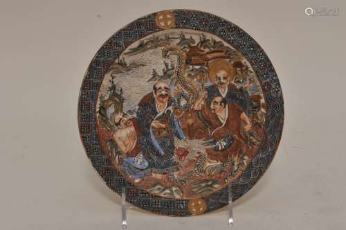 Pottery dish. Japan. Meiji period. (1868-1912). Relief decoration of four Buddhists saints (Rakan) and a dragon. Brocade borders and feet. Signed Satsuma. 7-1/8