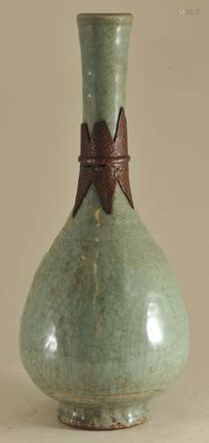 Porcelain bottle. China. Ming period (1368-1644). Lung Chuan ware. Sea green celadon of applied leaf shaped decoration burned brown in the firing. Surface carved with flowers. 13-1/2