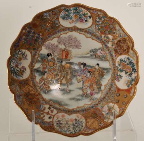 Stoneware saucer dish. Japan. Meiji period (1868-1912). Satsuma ware. Cherry blossom festival decoration. Fine brocade borders. Signed. Age crack to the base. 6-1/4