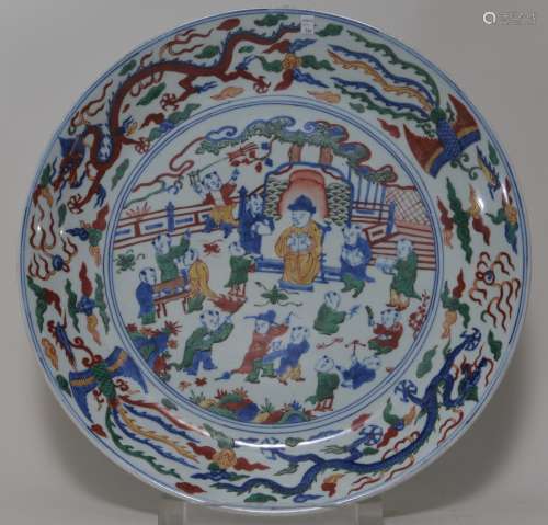 Large porcelain plate. China. Wan Li mark (1573-1619) and probably of the period. Wu Tsai ware. Decoration of children playing. Dragon and phoenix borders. Underglaze blue with red, green and yellow enamels. 19-3/4