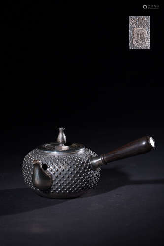 A SILVER TEAPOT WITH PATTERNS