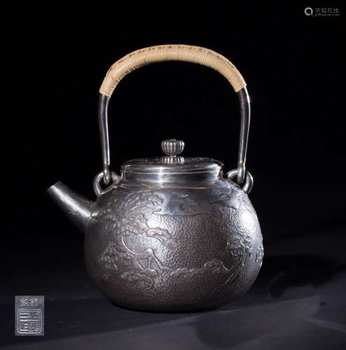 A SILVER TEAPOT WITH PATTERNS