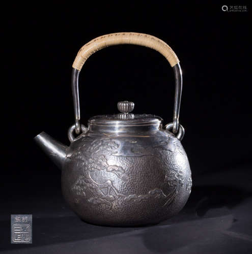 A SILVER TEAPOT WITH PATTERNS