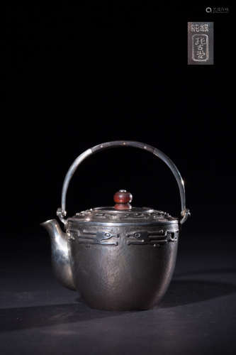 A SILVER TEAPOT WITH FLOWER PATTERNS