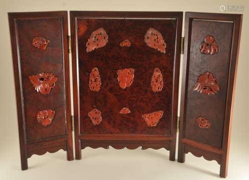 Three panel screen. China. 20th century. Rosewood frame with burlwood panels inset with carved carnelian. 13