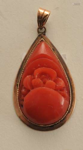 14k gold carved coral pendant. Pear-shaped, deep-red color, measuring approximately 24 x 15mm. Total weight of 4.2 grams. Hallmarked 14k.