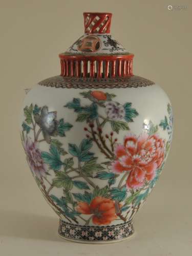 Porcelain covered jar. China. Early 20th century. Reticulated top and cover. Decoration of flowers in Famille Rose enamels. 7