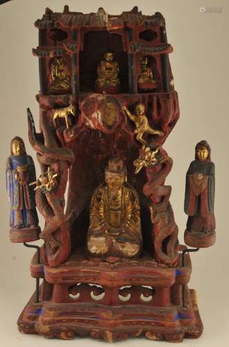 Carved wooden shrine grotto for a female deity with acolytes. China. 19th century. Carvings of dragons, a dog and child. Surface painted red and blue with gilt. 24