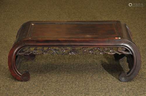 Rosewood Kang table. China, 19th century. Scroll shaped with the sides carved with flowering prunus. Aprons carved with flowers. 37