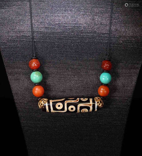 A DZI WITH BEADS CONNECT TO IT