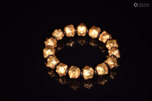 A BRACELET MADE OF GLASS BEADS COVERED BY PURE GOLD