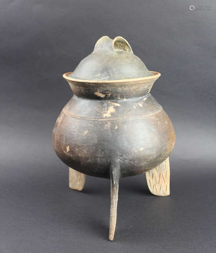 A BLACK PORCELAIN VESSEL WITH THREE LEGS