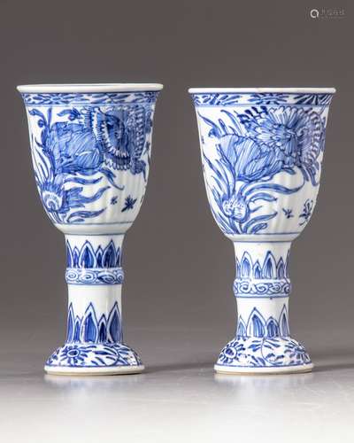 Two blue and white stemmed beakers