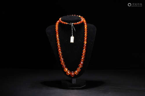 AN AMBER CARVED BEADS STRING NECKLACE