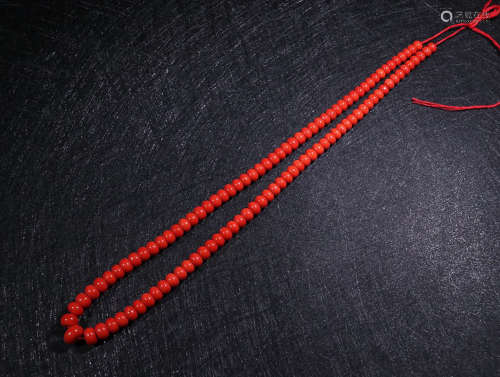 A STRING OF RED CORAL BEADS