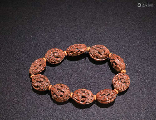 A WALNUT MADE BRACELET OF STORY-TELLING PATTERN