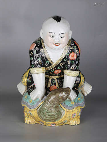 Chinese famille rose porcelain figure of a boy riding on a tortoise.