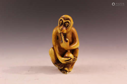 A Japanese carving of a monkey with a frog.
