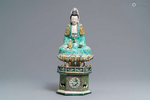 A Chinese verte biscuit group of Guanyin with child on a lotus throne, Kangxi