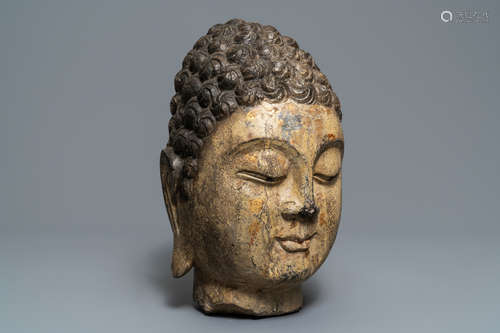 A Chinese carved stone head of Buddha with traces of gilding and polychromy, Ming