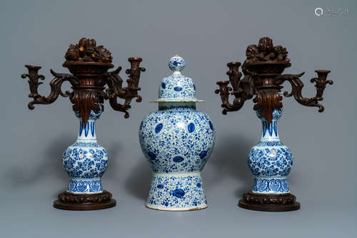 A Dutch Delft blue and white three-piece garniture with carved wooden candleholders, 18th C.