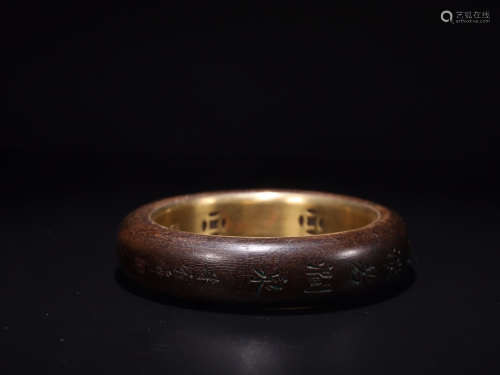 A CHENXIANG WOOD BANGLE WITH GILT SILVER EMBEDED
