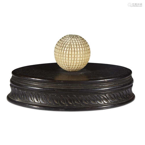 A CARVED IVORY OR BONE BALL ON BASE