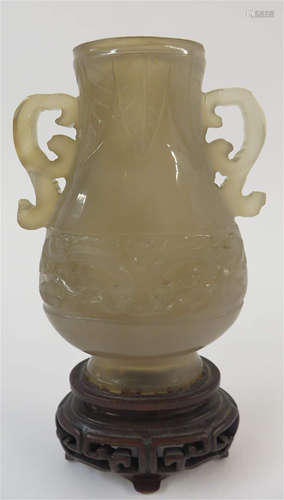 A Chinese carved twin-handled smokey agate taotie vase mounted with stand