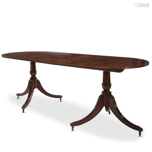 A Regency style string inlaid figured mahogany double pedestal dining table