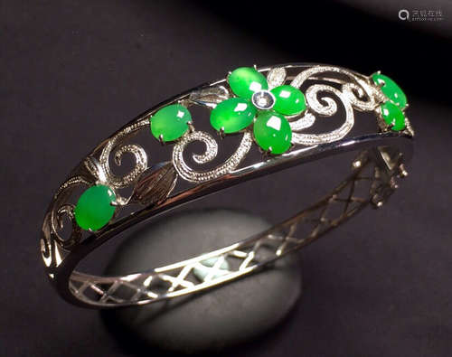 A GREEN JADEITE BRACELET WITH BLOSSOMING FLOWER PATTERNS