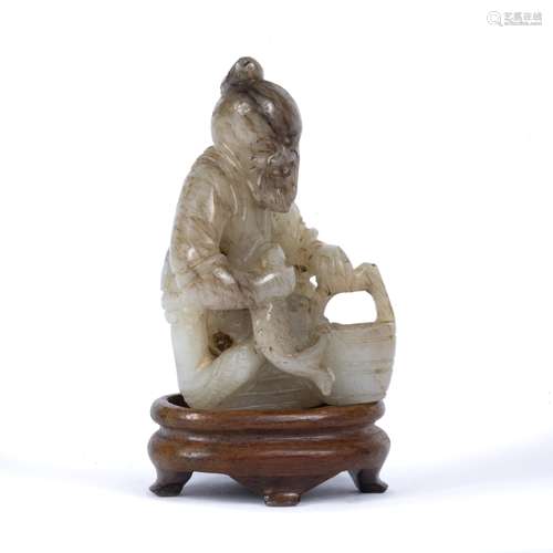 Jade carving of a fisherman Chinese, 19th Century the seated figure holding a fish in his right hand