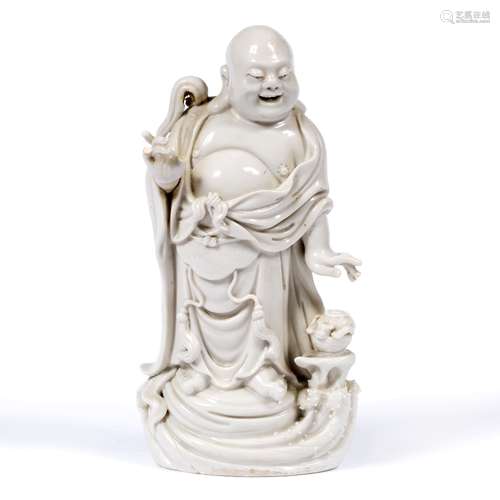 Blanc de chine figure of Budai Chinese, 19th/20th Century with a jovial expression. 23cm high