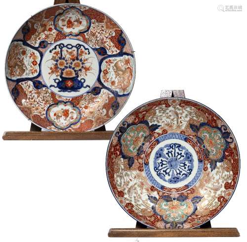 Two large Imari chargers of white ground form, each with a central panel, the first depicting a