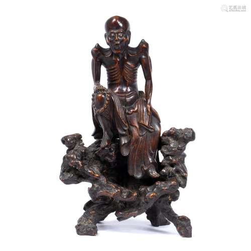 Root carved Lohan Chinese, 18th/19th Century the figure holding a rosary on his right knee 31.5cm