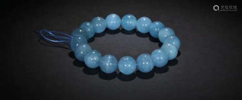 AN AQUAMARINE CARVED BEADS STRING BRACELET