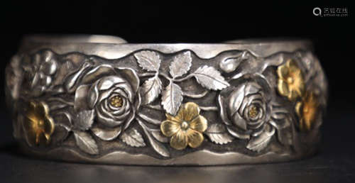 A SILVER CASTED FLOWER PATTERN BANGLE