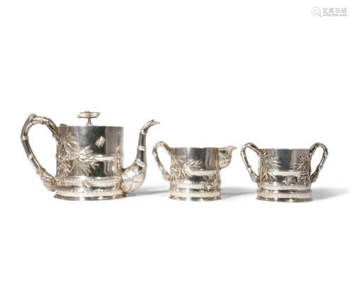 λ A CHINESE SILVER THREE-PIECE TEA SET C.1900 Comprising: a teapot, a sugar bowl and a cream jug,