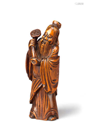 A CHINESE BOXWOOD CARVING OF AN IMMORTAL QING DYNASTY Standing, wearing long robes, smiling, with