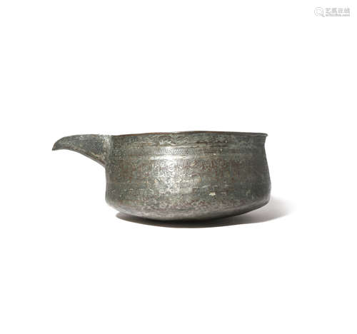 A MAMLUK TINNED-COPPER POURING VESSEL PROBABLY 14TH/15TH CENTURY With a compressed circular body and