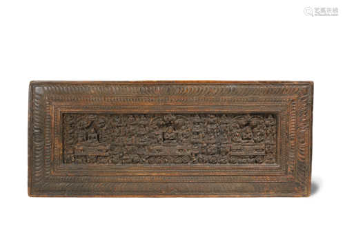 A RARE TIBETAN CARVED WOOD BOOK COVER 14TH CENTURY Decorated with three Buddhist figures elevated on