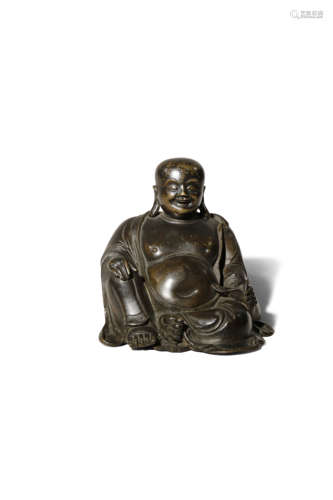 A CHINESE BRONZE FIGURE OF BUDAI HE SHANG LATE 17TH CENTURY Seated in a relaxed pose with his