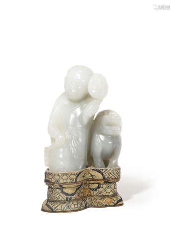 A CHINESE PALE CELADON JADE CARVING OF A FOREIGNER WITH A LION DOG QING DYNASTY The figure stands