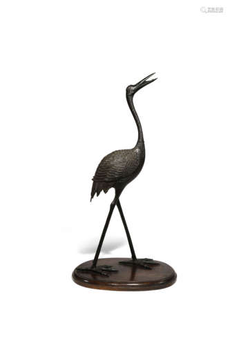 A CHINESE BRONZE MODEL OF A CRANE LATE QING DYNASTY The bird stands tall with is feet apart its head