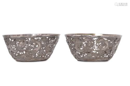 A PAIR OF CHINESE PIERCED SILVER 'DRAGON' BOWLS.