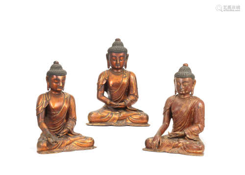 17th/18th century  A rare set of three gilt-lacquered wood figures of the Buddha