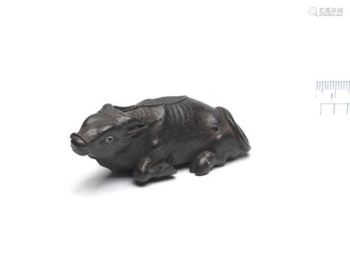 By Kanman (1793-1859), Iwami Province, early 19th century An ebony netsuke of a recumbent ox