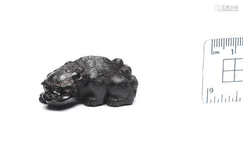 By Kanman (1793-1859), Iwami Province, early 19th century An ebony netsuke of a shishi