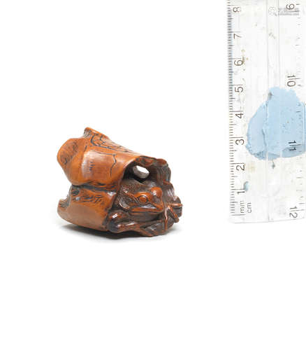 By Mitani Goho, Aki Province, late 18th/early 19th century A boxwood netsuke of a frog emerging from a rotted branch