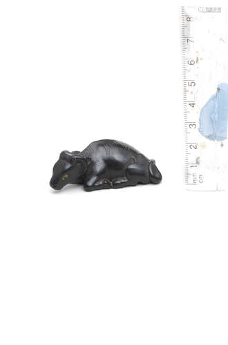 By Kanman (1793-1859), Iwami Province, early 19th century A small ebony netsuke of a recumbent ox